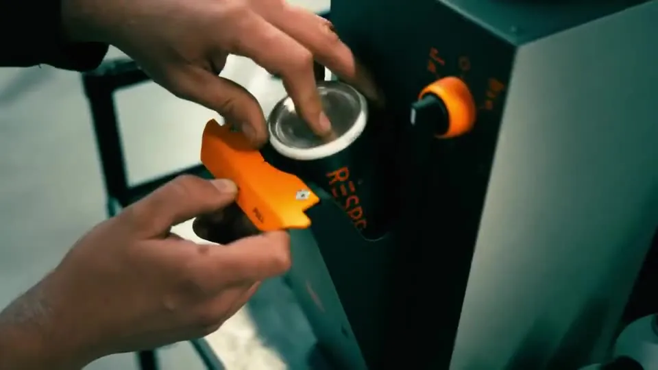A szerelő a palackot az automatába helyezi